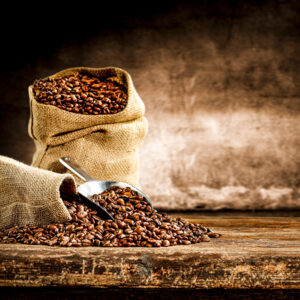 Fresh old sack of coffee grains and brown old wall background
